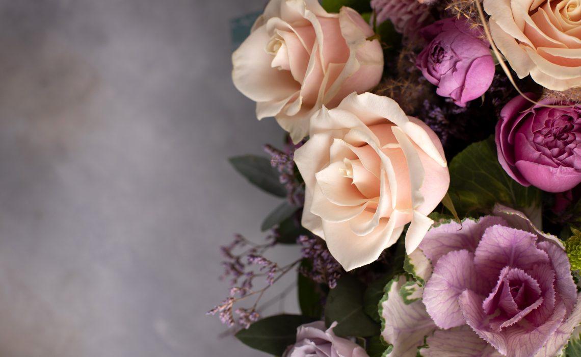 flower border of assorted fresh flowers on a gray background. horizontal image, copy space, top view